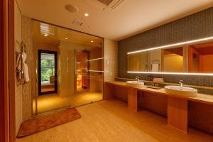 a bathroom with two sinks and two mirrors at Sakunami Onsen Yuzukushi Salon Ichinobo in Sendai