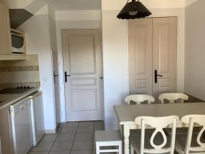 cocina con mesa y sillas en Duplex (5pers) dans village vacances en Ardèche, en Grospierres