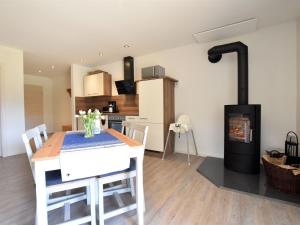 a kitchen and dining room with a table and a fireplace at Cozy Apartment in Barnekow with Private Terrace in Barnekow