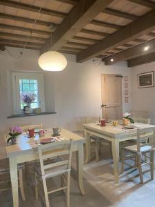 Poderino - a place to feel في Cento: غرفة طعام مع طاولات وكراسي خشبية