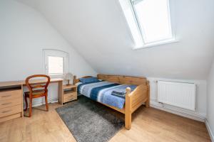 een slaapkamer met een bed, een bureau en een stoel bij Private Apartment in Hannover