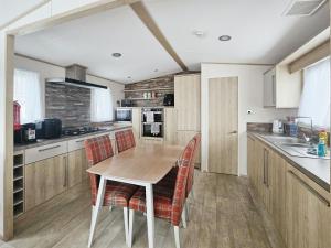 a kitchen with a wooden table and chairs at Hot Tub Lodge in the Cotswolds - Pet Friendly in South Cerney