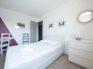 Habitación blanca con cama y espejo en Confortable, lumineux et agréable T3, en Montpellier