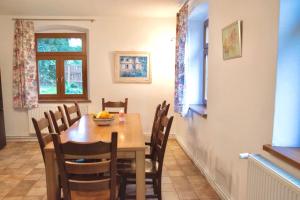 a dining room with a table and chairs at Folwark Sudecki in Marciszów