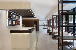 - un hall d'un restaurant avec un comptoir et des chaises dans l'établissement Mulan Hotel, à Tel Aviv