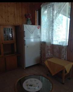 cocina con nevera, mesa y ventana en Rent House: Velanidiá, en Makryámmos