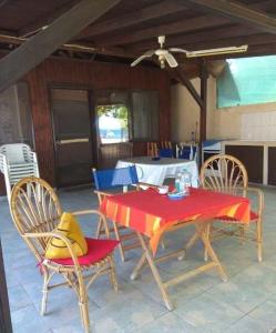 un patio con mesa, sillas y mantel rojo en Rent House: Velanidiá, en Makryámmos