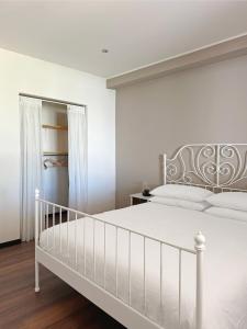 a white bedroom with a white bed and a closet at Villa Ramadia in Floridia