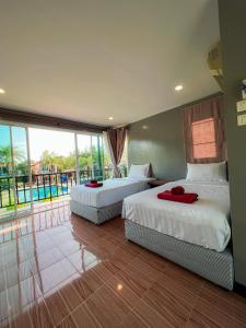 two beds in a room with a view of a pool at รัตนารีสอร์ท ลันตาน้อย in Ban Mo Nae