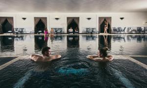 duas pessoas na água numa piscina em Fairlawns, Hotel And Spa em Walsall