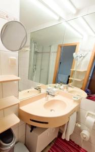 een badkamer met een wastafel en een spiegel bij Ferienwohnung Wallner Rosi in Sankt Englmar