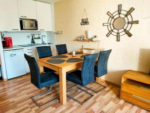 a dining room table with blue chairs and a kitchen at Ferienwohnung Wallner Rosi in Sankt Englmar