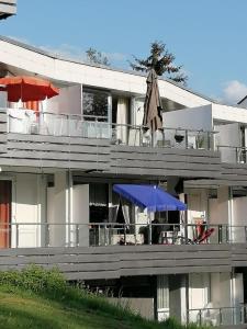 een gebouw met een balkon met parasols erop bij Ferienwohnung Wallner Rosi in Sankt Englmar