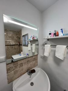 Un baño blanco con lavabo y espejo. en San Antonio, en Alhaurín el Grande