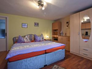 ein Schlafzimmer mit einem großen Bett mit lila Kissen in der Unterkunft Cozy apartment in Boltenhagen Germany near the beach in Boltenhagen