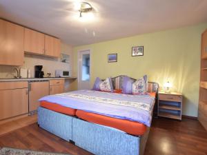 a bedroom with a large bed and a kitchen at Cozy apartment in Boltenhagen Germany near the beach in Boltenhagen