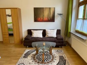 a living room with a couch and a glass table at Ferienwohnung im Zentrum Zwickaus in Zwickau