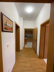 - un couloir avec des murs blancs et du parquet dans l'établissement Ferienwohnung im Zentrum Zwickaus, à Zwickau