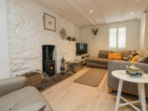 a living room with a stone fireplace and a couch at Riversdale Cottage in Wadebridge