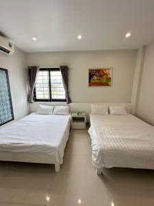 two beds in a room with two windows at Hotel Me Kong in Ha Long
