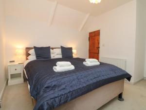 a bedroom with a bed with two towels on it at Riversdale Cottage in Wadebridge