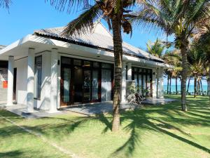 una casa con palme di fronte di Starlight Villa Beach Resort & Spa a Phan Thiet
