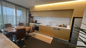 cocina con mesa y cocina con encimera en 2 Bedroom Apartment Eco Living at Nishi Canberra, en Canberra