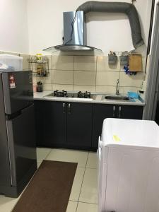 a kitchen with a sink and a stove top oven at Palas Horizon in Kabus in Brinchang