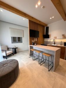 a kitchen with a counter and stools in a room at Poema Antiparos in Antiparos