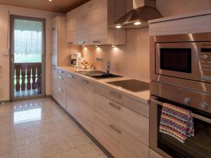 a kitchen with wooden cabinets and a stove top oven at Cosy farmhouse apartment at the edge of the forest in Mühlenbach