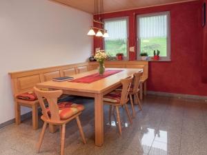 a dining room with a wooden table and chairs at Cosy farmhouse apartment at the edge of the forest in Mühlenbach
