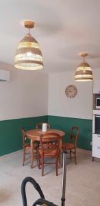 a kitchen with a table and chairs and two lights at Un Nid en Sologne in Contres +5 photos