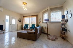 un soggiorno con divano, sedie e TV di Estell’s sweet luxury house a Volos