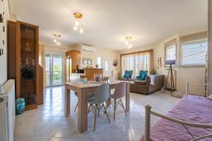 una cucina e un soggiorno con tavolo e sedie di Estell’s sweet luxury house a Volos