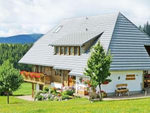 ein großes weißes Haus mit einem Gameradach in der Unterkunft Haldenmichelhof Ferienwohnungen in Breitnau