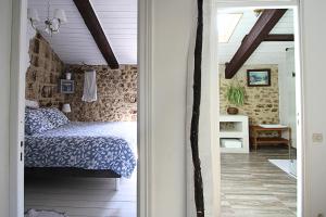 ein Schlafzimmer mit einem Bett und einer Tür, die zu einem Flur führt in der Unterkunft Ancienne maison en pierre au coeur du village in Usclas-lʼHérault