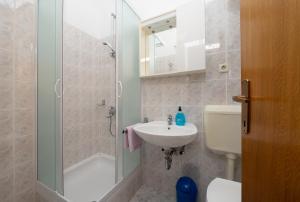 a bathroom with a shower and a sink and a toilet at Rooms Olive and Sea in Tučepi