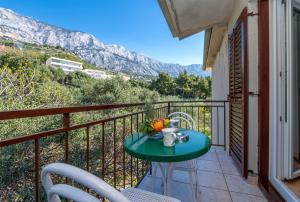 a table on a balcony with a view of a mountain at Rooms Olive and Sea in Tučepi +34 photos