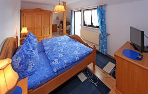 a bedroom with a bed with a blue comforter at Amazing Apartment In Userin With Kitchen in Userin