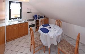 eine Küche mit einem Tisch, Stühlen und einem Waschbecken in der Unterkunft Amazing Apartment In Userin With Kitchen in Userin