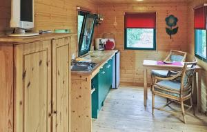a kitchen with a stove and a table in a cabin at 1 Bedroom Cozy stacaravan In Warthe in Warthe