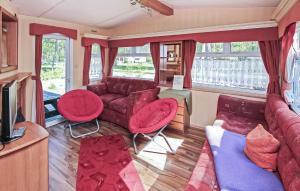 sala de estar con sofá y sillas rojas en Beautiful stacaravan In Rheinsberg Ot Kagar With Kitchen, en Kagar