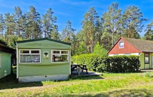 una casita verde con una mesa de picnic en un patio en Beautiful stacaravan In Rheinsberg Ot Kagar With Kitchen, en Kagar
