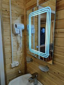 La salle de bains est pourvue d'un miroir et d'un lavabo. dans l'établissement Kottage anania, à Batoumi