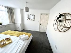 a white room with a bed and a mirror at Modern 2 bed close to mall with parking & garden in Golders Green