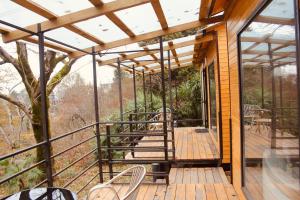 a wooden deck with chairs and tables on it at Kottage anania in Batumi