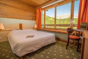 a bedroom with a bed and a desk and a window at Villages Clubs du Soleil - VARS in Vars