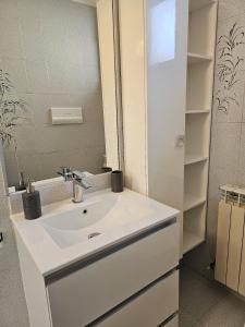 y baño con lavabo blanco y espejo. en La Casa della Lavanda, en Borgo Adorno