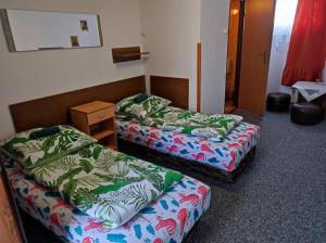 Pokój z 2 łóżkami i stołem z koszulkami w obiekcie Motel Korona w mieście Zamość