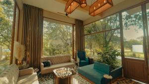 a living room with a couch and a large window at Giovanni Village Resort in Bhopal